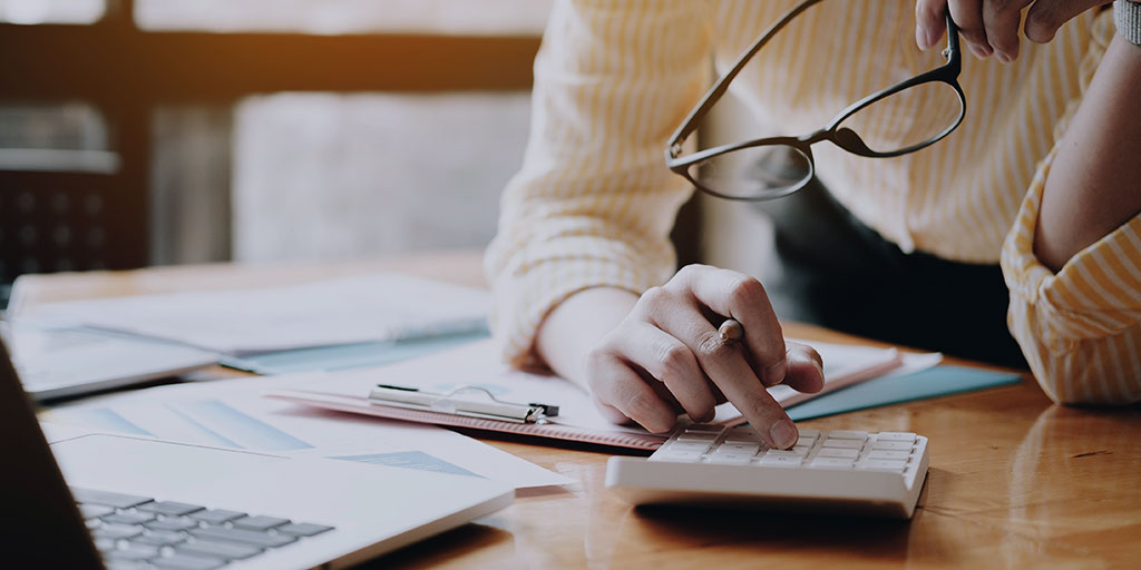 Close up Business woman using calculator and laptop for do math